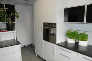 una cocina con armarios blancos y macetas en Słoneczny apartament w Sopocie en Sopot