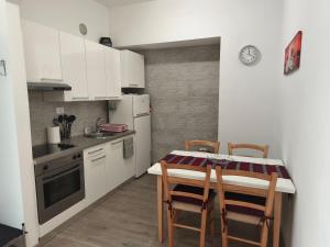 a kitchen with a table and chairs and a refrigerator at Apartment Možina in Koper