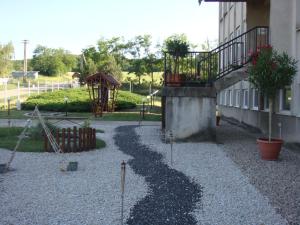 a gravel yard with a playground next to a building at Chrám Ticha in ľubá