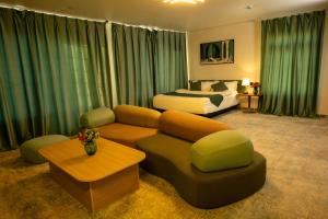 una sala de estar con un sofá y una cama en MSInternational Hotel, en Ulán Bator