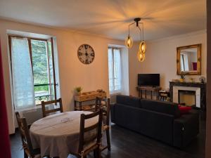 a living room with a couch and a table at le galeta cosy calme et chaleureux avec vue sur la montagne in Aigueblanche