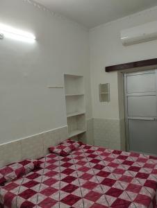 a bedroom with a red and white checkered bed at Balaji guest house in Jāmb