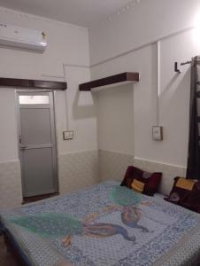 a bedroom with a bed with a painting on it at Balaji guest house in Jāmb