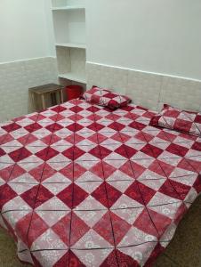 a red and white quilt on a bed in a room at Balaji guest house in Jāmb +2 photos