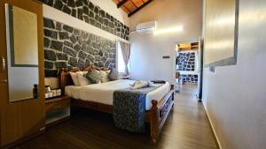 a bedroom with a bed and a stone wall at Le Yercaud in Yercaud +122 photos