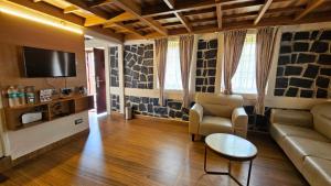 a living room with a couch and a tv at Le Yercaud in Yercaud