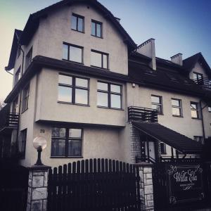 a large white house with a black fence at Willa Ela in Gdańsk