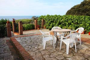a patio with three chairs and a table at Casa de Aldea El Valle in Buelna