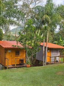 ein Holzhaus mit orangefarbenem Dach im Hof in der Unterkunft Cabana Hostel Eco Park in São Pedro