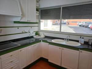una cocina con 2 lavabos y una ventana grande en Salinetas VISTAMAR, en Telde