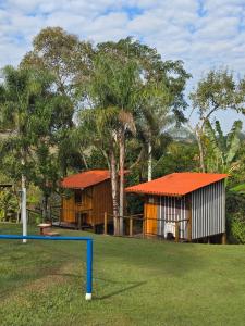 ein Haus mit einem orangefarbenen Dach und einer Wippe in der Unterkunft Cabana Hostel Eco Park in São Pedro
