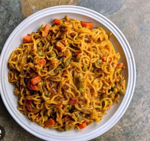 a plate of noodles and vegetables on a table at Mount lake in Bhīm Tāl