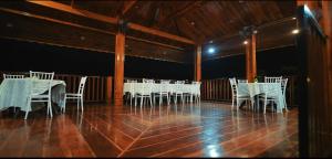 a group of white tables and chairs in a room at Sopo Resort in Duimukh