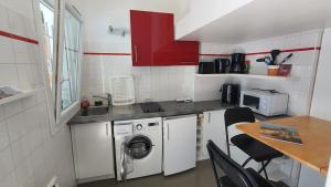 a small kitchen with a washing machine and a table at Studette à 3km des plages ANGLET - BIARRITZ in Anglet