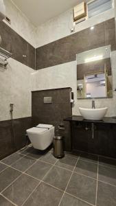a bathroom with a sink and a toilet and a mirror at Le Yercaud in Yercaud
