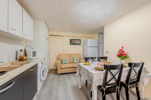 une cuisine et un salon avec une table et des chaises dans l'établissement Location meublé Ty Kim, à Le Folgoët