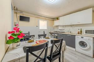 une cuisine et une salle à manger avec une table et des chaises dans l'établissement Location meublé Ty Kim, à Le Folgoët