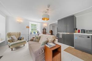 a living room with a couch and a kitchen at Mackinnon Cottage - 3 bedroom Cottage in Broadford