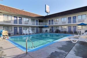 a swimming pool in front of a hotel with chairs at Studio 6 San Angelo, Tx in San Angelo