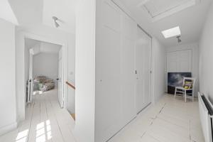 - un couloir blanc avec des murs et des sols blancs dans l'établissement Mackinnon Cottage - 3 bedroom Cottage, à Broadford