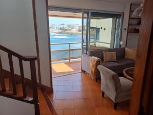 a living room with a couch and a balcony with the ocean at Sobre el Mar by CanariApartment, Oceanfront House with 3 Balconies in Salinetas in Telde