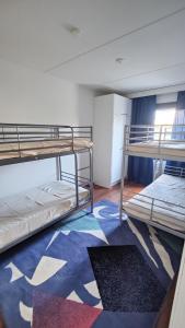 a dorm room with two bunk beds and a rug at Spacious 3-room stay near Airport in Vantaa
