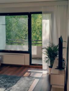 a living room with a large window and a tv at Spacious 3-room stay near Airport in Vantaa
