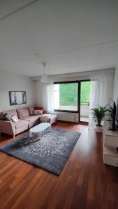 a living room with a couch and a rug at Spacious 3-room stay near Airport in Vantaa +2 photos