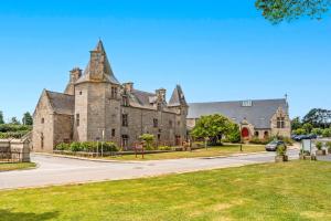 un vieux bâtiment en pierre avec une tour dans une rue dans l'établissement Location meublé Ty Kim, à Le Folgoët