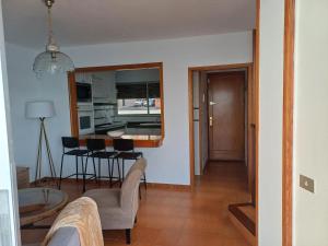 Una sala de estar y una cocina con mesa y sillas. en Salinetas VISTAMAR, en Telde