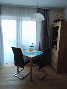 una mesa de comedor y sillas en una habitación con ventana en Prime Studio, en Leutasch 3 fotos más