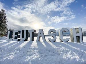 Un cartel en la nieve con el sol detrás. en Prime Studio, en Leutasch