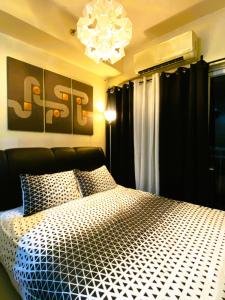 a bedroom with a large bed and a chandelier at Chateau Staycation in Manila