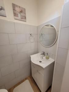 ein weißes Badezimmer mit Waschbecken und Spiegel in der Unterkunft N&M apartments in Vodice + 27 Fotos