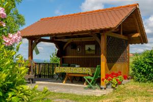 a wooden gazebo with a bench and a table at Vineyard cottage Rustika in Novo Mesto