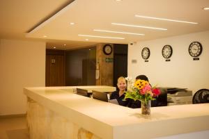 two women sitting in an office with a reception desk at Hotel La Riviera in Santa Marta +45 photos
