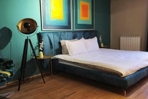 a bed in a room with paintings on the wall at Main square - Palace La Grande 150 m2 in Skopje
