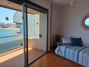 Un dormitorio con una cama y vista al agua. en Salinetas VISTAMAR, en Telde