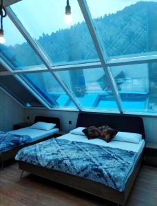 deux lits dans une chambre avec une grande fenêtre dans l'établissement Al Najm Resorts, à Nārān