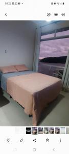 a bed in a room with a window at Kitão PÉ na Areia in São Vicente