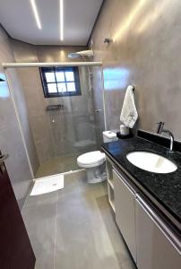 a bathroom with a shower and a sink and a toilet at Apto Funcional próximo a Orla do Centro HS2 in Ubatuba