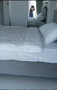 a bed with white sheets and pillows in a room at Bedroom flat Caesar resort, Iskele north Cyprus in Vrysoules