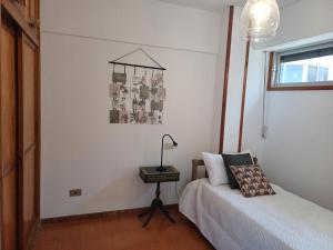 Un dormitorio con una cama y una mesa con una lámpara. en Salinetas VISTAMAR, en Telde