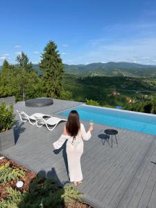 a woman standing on a deck next to a swimming pool at Rest Hub in Slavske