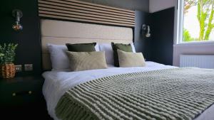 Un dormitorio con una gran cama blanca con ventana. en Daverneithon 3, en Rhayader