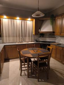 cocina con mesa y sillas y cocina con fregadero en Sonata apartment, en Argostoli