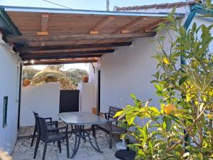 un patio con mesa y sillas bajo toldo en Bungalow Asseiceira, en Santo António das Areias