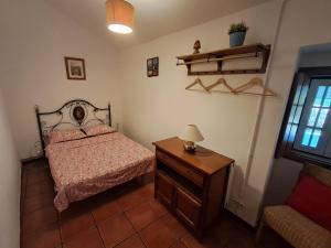 Un dormitorio con una cama y una mesa con una lámpara. en Bungalow Asseiceira, en Santo António das Areias