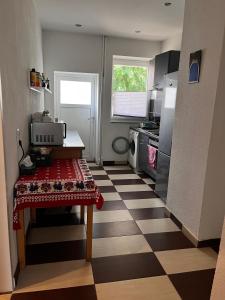 una cocina con suelo a cuadros y mesa. en Altstadt Apartmenthaus, en Kassel