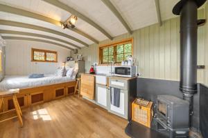 a kitchen with a bed and a stove in a room at Corry Lodge Estate - Sheperds Huts or Container Stays with Sea View in Broadford